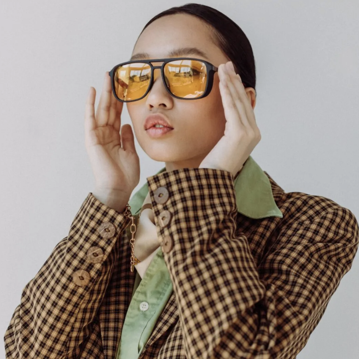 Portrait of a woman in tinted glasses and a check blazer